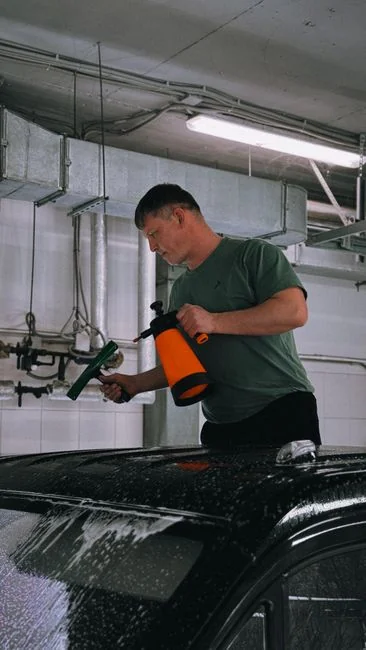 A worker in protective gear disinfects a kitchen, ensuring a clean and safe environment.